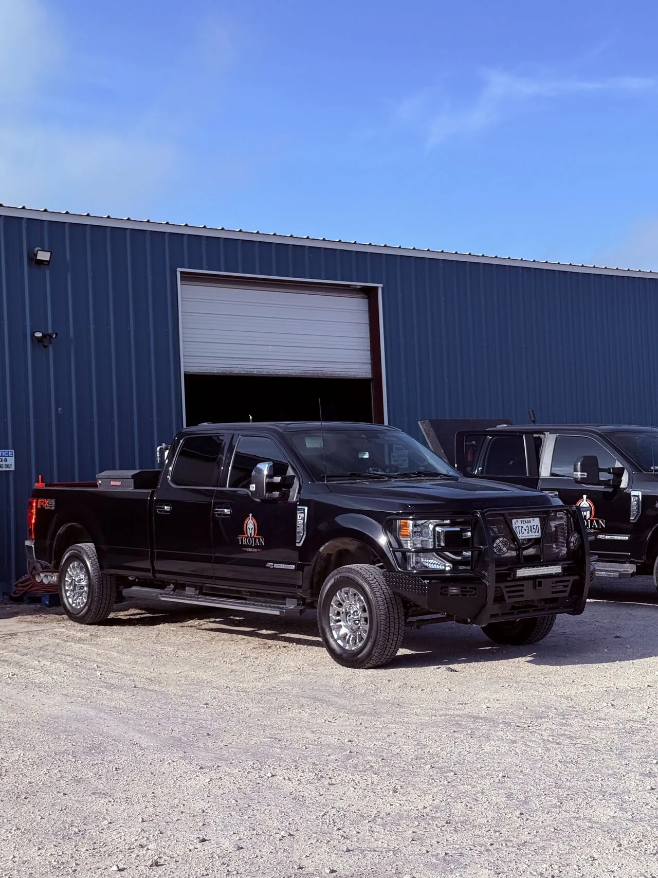 Black Trojan Wireline crew trucks parked outside the company's Alice, Texas shop.